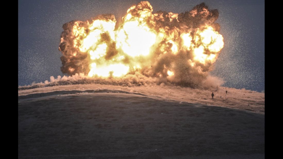 ISIS militants stand near the site of an airstrike near the Turkey-Syria border on Thursday, October 23. The United States and several Arab nations have been bombing ISIS targets in Syria to take out the militant group's ability to command, train and resupply its fighters.