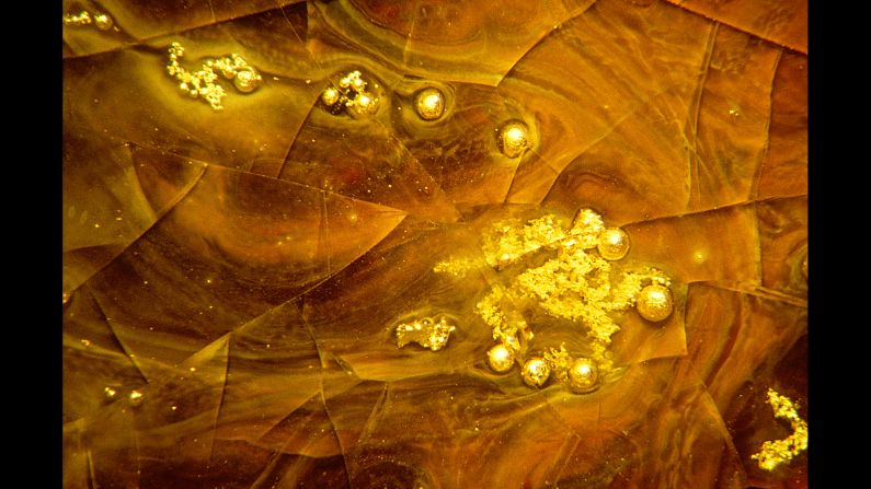 Gold residue and gold-coated bubbles in a glassy matrix