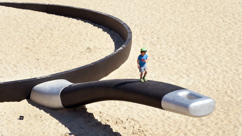 A boy climbs on the handle of a giant frying pan Thursday, October 23, in Sydney. The pan is the work of artist Andrew Hankin, and it is part of the Sculpture by the Sea exhibition that runs until November 9.