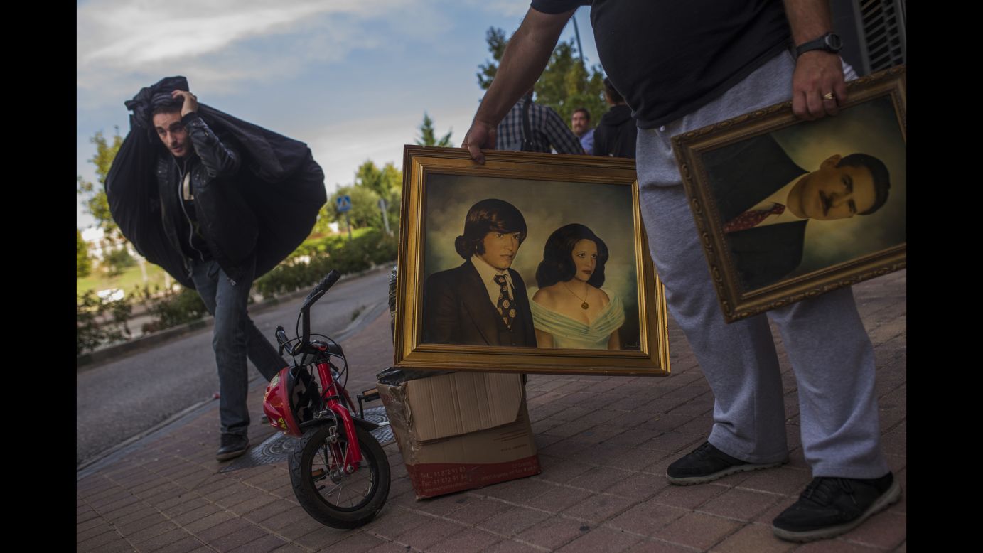 An activist and a friend carry Veronica Lebradas' belongings after police evicted her and her family in Madrid on Wednesday, October 22. Evictions have been common in many parts of Spain, which has been struggling with a recession and unemployment.