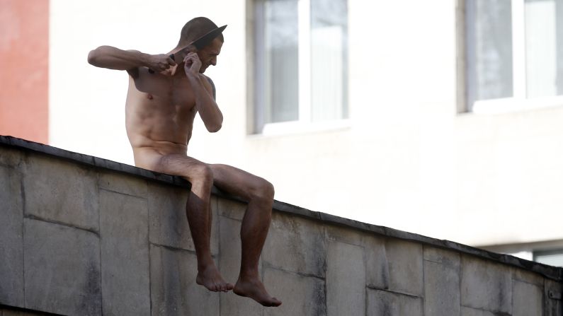 Pyotr Pavlensky cuts off a part of his earlobe Sunday, October 19, while sitting on a wall enclosing the Serbsky Center, a psychiatric hospital in Moscow. Pavlensky was protesting what he said was the use of forensic psychiatry for politically motivated purposes. He said he cut off part of his earlobe to demonstrate how authorities could "cut off" an unwanted individual from society.