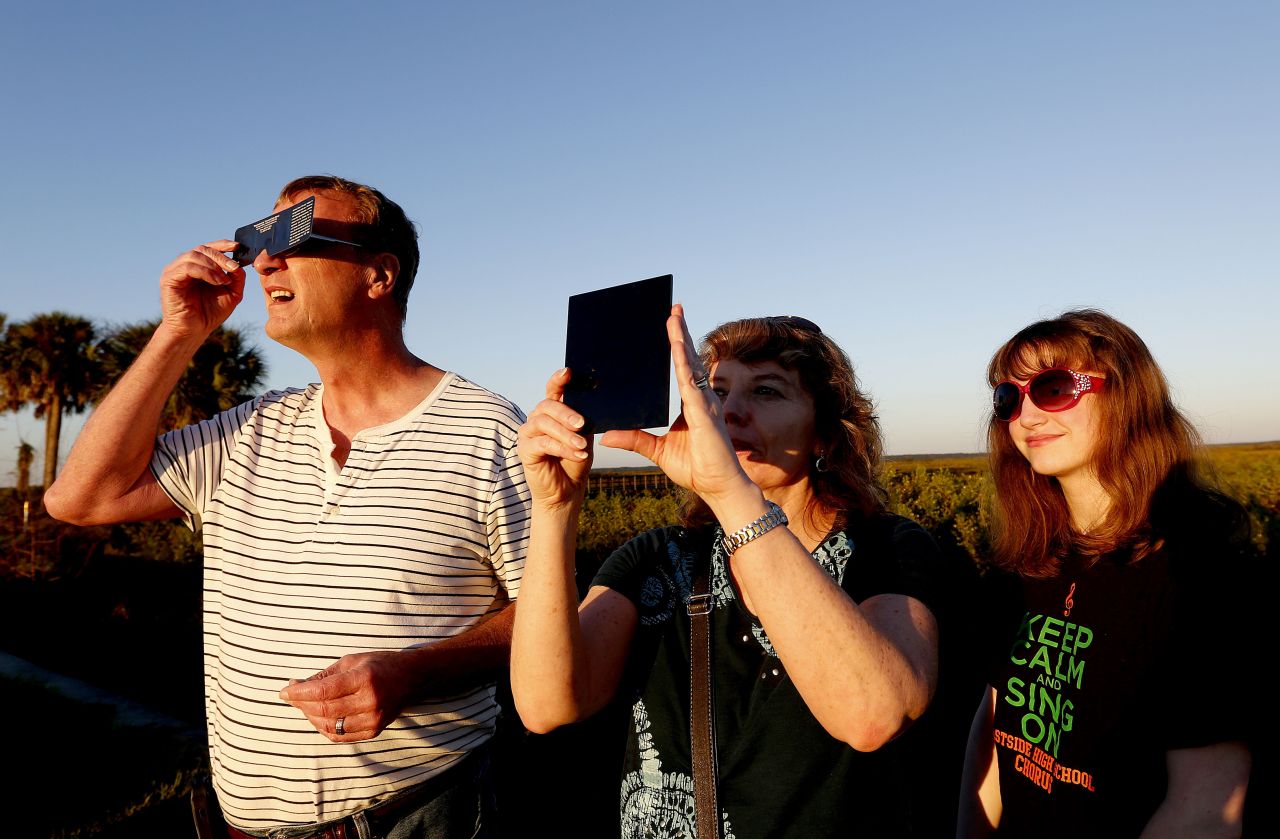 Andy, Cathy and Jessica Howell look at a partial eclipse of the sun on Thursday, October 23, in Gainesville, Florida. The solar eclipse was visible for most North Americans. Click through for more views: