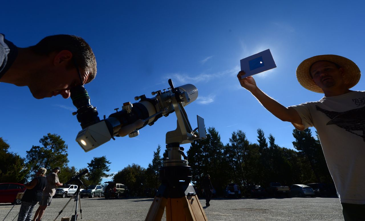 Norm Vargas holds a filter so another person can view the eclipse through a telescope at Mount Wilson Observatory in the San Gabriel Mountains northeast of Los Angeles.