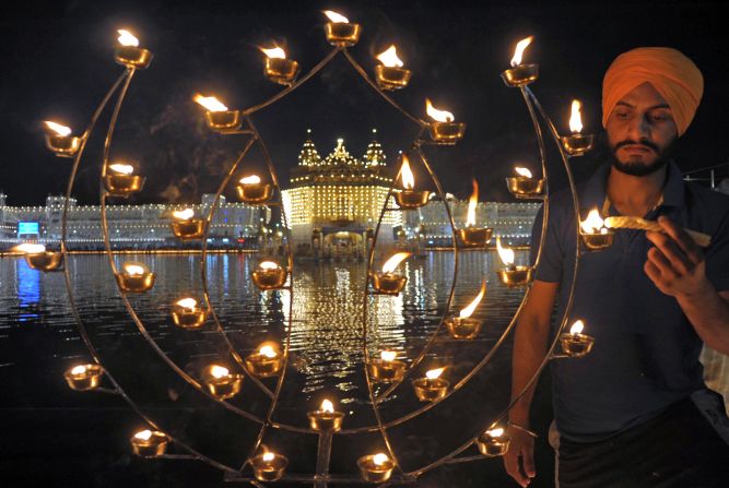 An Indian Sikh devotee lights candles at the illuminated Golden Temple in Amritsar. Though the three faiths celebrate Diwali -- the name comes from the word Deepavali, meaning "row of lights" -- in different ways, the main theme symbolizes the victory of good over evil and light over darkness.