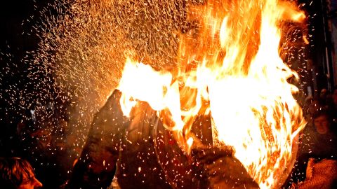 A flaming barrel is passed between to participants at bonfire celebrations in Ottery St. Mary in Devon, England.