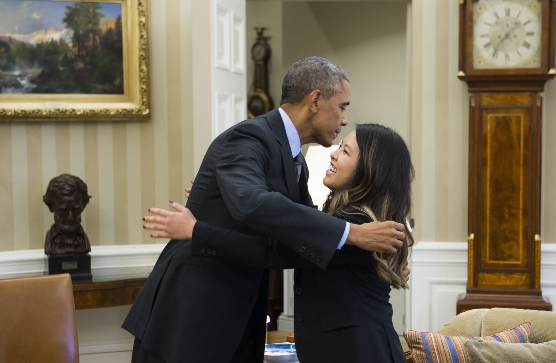 US President Barack Obama hugs nurse Nina Pham, who was declared free of the Ebola virus after contracting the disease while caring for a Liberian patient in Texas, during a meeting in the Oval Office of the White House in Washington, DC, October 24, 2014. AFP PHOTO / Saul LOEB (Photo credit should read SAUL LOEB/AFP/Getty Images)