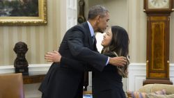 US President Barack Obama hugs nurse Nina Pham, who was declared free of the Ebola virus after contracting the disease while caring for a Liberian patient in Texas, during a meeting in the Oval Office of the White House in Washington, DC, October 24, 2014. AFP PHOTO / Saul LOEB (Photo credit should read SAUL LOEB/AFP/Getty Images)