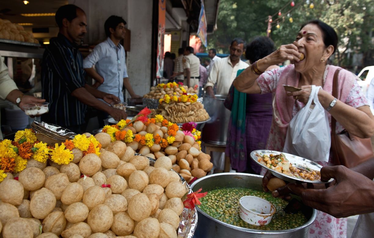 Diwali is also a time for exchanging gifts -- traditionally sweets and dried fruit, which are in abundance on the streets in the run up to the festival. Here, a woman samples some gol gappas at a roadside snack shop in New Delhi. 