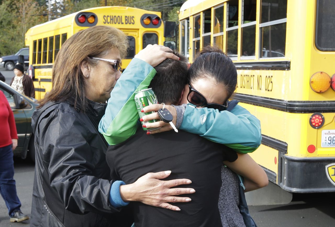 People embrace at the church where students were taken to be reunited with parents.