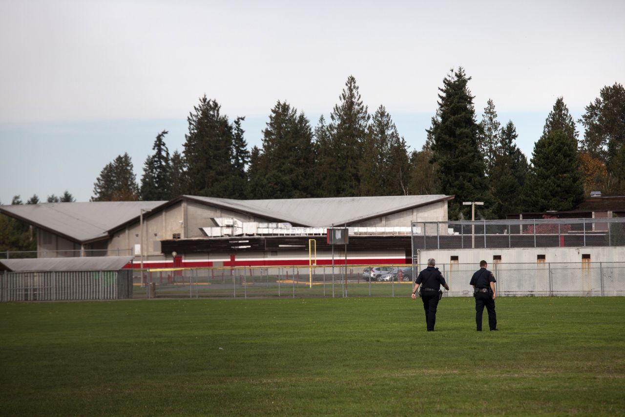 Police monitor the school's athletic fields after the shooting. 