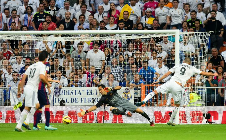 Benzema (right) slides his shot past Cladio Bravo to score Real Madrid's third goal against Barcelona in a 3-1 win at the Bernabeu in October 2014.