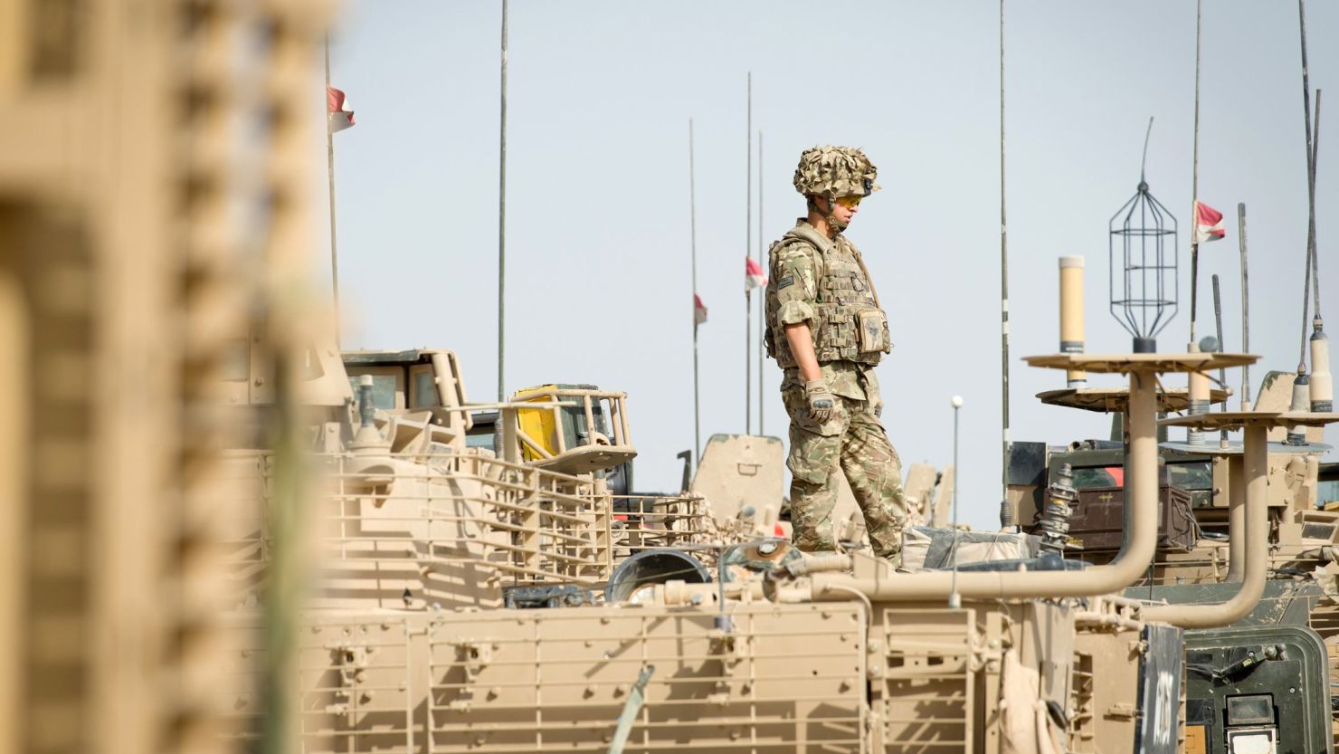 A British soldier stands on top of an armoured vehicle as UK PM David Cameron visits Camp Bastion on June 29, 2013.