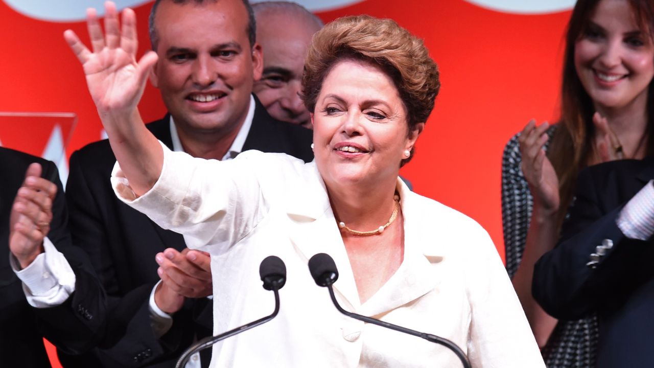 Re-elected Brazilian President Dilma Rousseff waves following her win, in Brasilia on October 26, 2014. Leftist incumbent Dilma Rousseff was re-elected president of Brazil, the country's Supreme Electoral Tribunal said, after a down-to-the-wire race against center-right challenger Aecio Neves. Rousseff, who had 51.45 percent of the vote with 98 percent of ballots counted, was declared the run-off winner. AFP PHOTO / EVARISTO SA