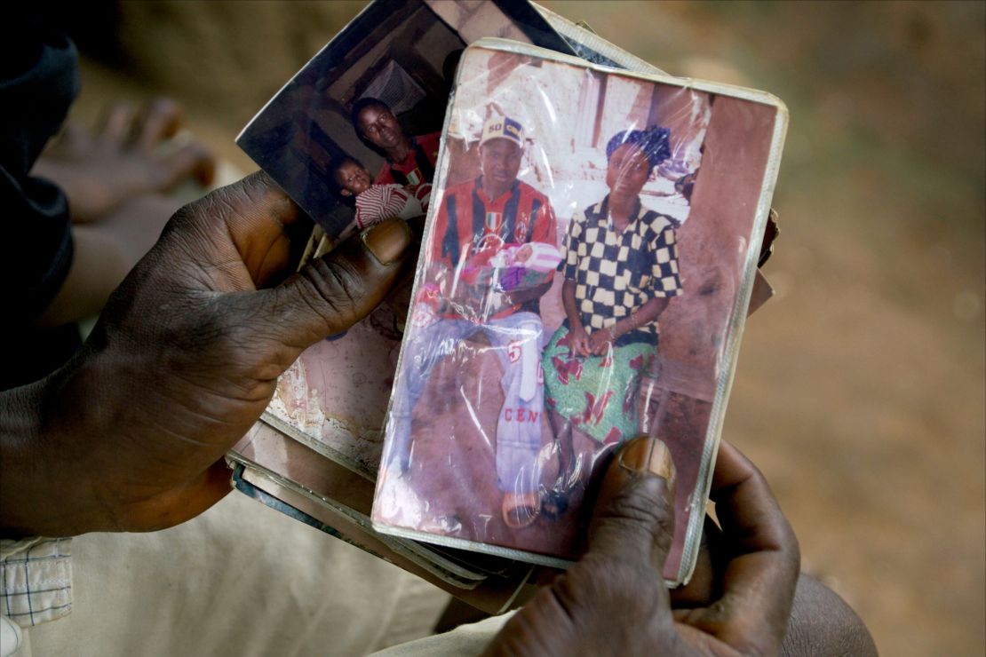 Etienne Ouamouno holds a photo of his wife and son Emile. Researchers think the boy was the outbreak's first victim.