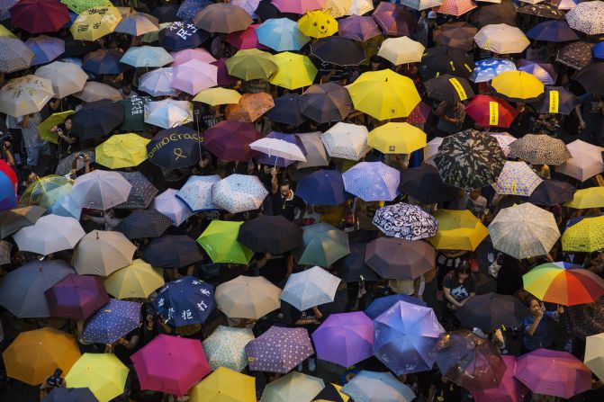 People open umbrellas at the main protest site in Hong Kong on Tuesday, October 28. The umbrella has become <a href="index.php?page=&url=http%3A%2F%2Fwww.cnn.com%2F2014%2F09%2F30%2Fworld%2Fasia%2Fobjects-hong-kong-protest%2Findex.html">the defining image of the protest movement,</a> used to shield protesters from tear gas and the elements. 
