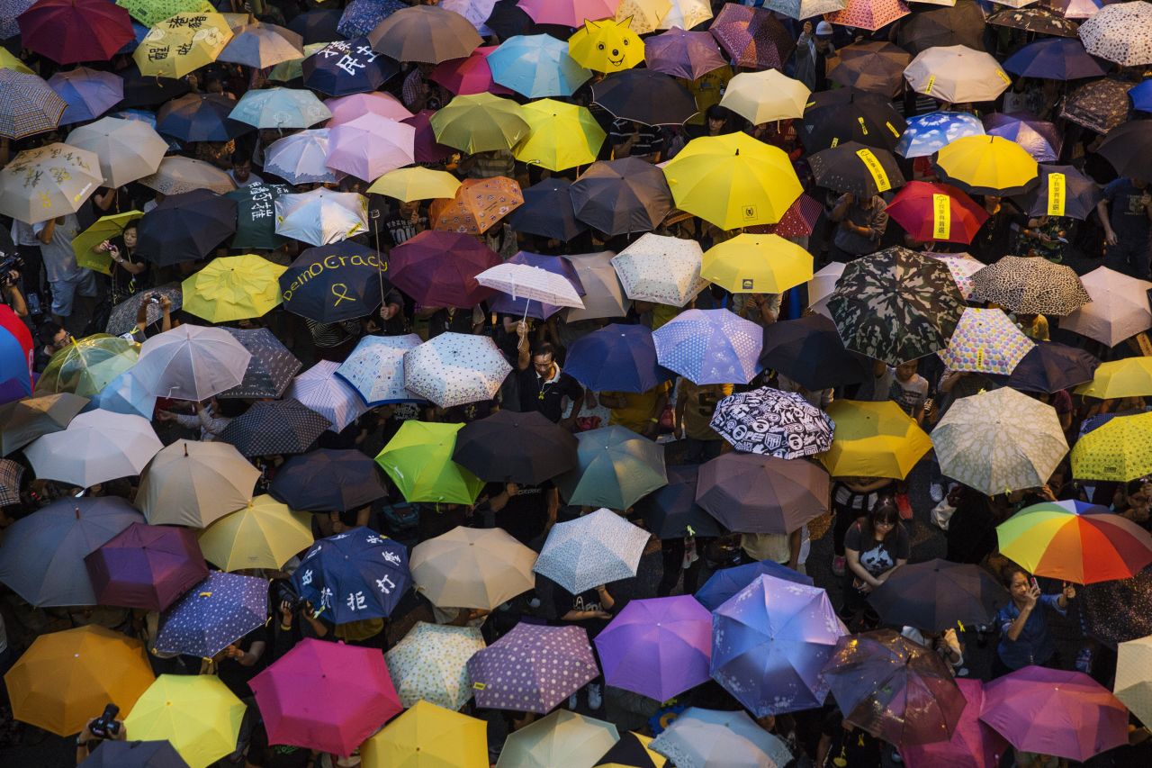 People open umbrellas at the main protest site in Hong Kong on Tuesday, October 28. The umbrella has become <a href="http://www.cnn.com/2014/09/30/world/asia/objects-hong-kong-protest/index.html">the defining image of the protest movement,</a> used to shield protesters from tear gas and the elements. 