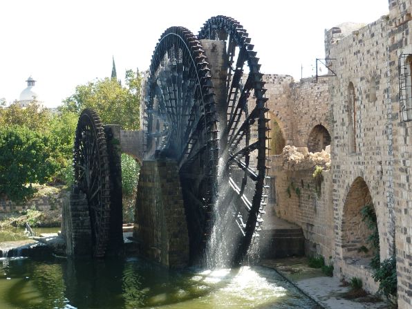 These 20-meter wide water wheels were first documented in the 5th century, representing an ingenious early irrigation system. Seventeen of the wooden norias (a machine for lifting water into an aqueduct) survived to present day and became Hama's primary tourist attraction, noted for their groaning sounds as they turned. Heritage experts <a href="index.php?page=&url=http%3A%2F%2Fwww.dgam.gov.sy%2Findex.php%3Fp%3D314%26id%3D1374" target="_blank" target="_blank">documented several wheels</a> being burned by fighters in 2014.