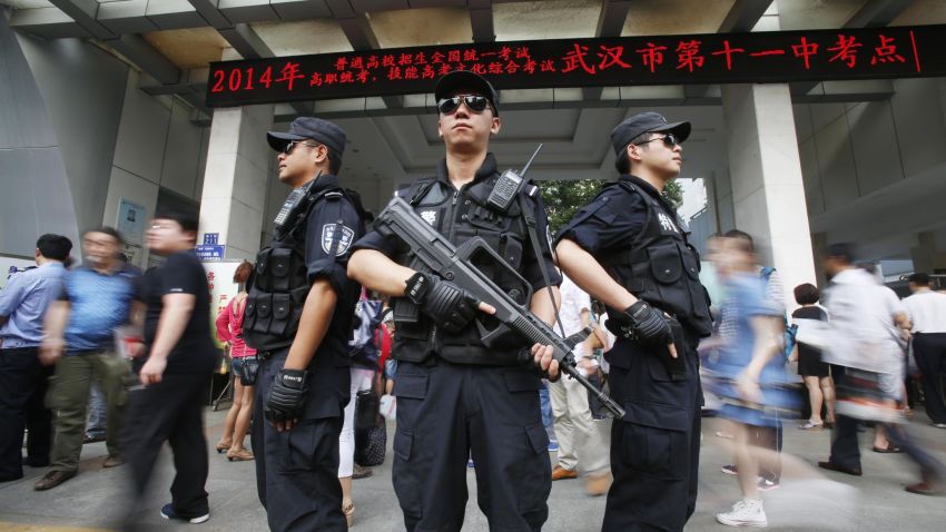 Armed policemen stand on patrol at the gate of a high school as students sit the 2014 college entrance exam of China, or the 'gaokao', in Wuhan, central China's Hubei province on June 7, 2014. Nearly 10 million high school students are sitting for China's make-or-break college entrance exams under tight security on June 7 to June 8. CHINA OUT AFP PHOTO (Photo credit should read AFP/AFP/Getty Images)