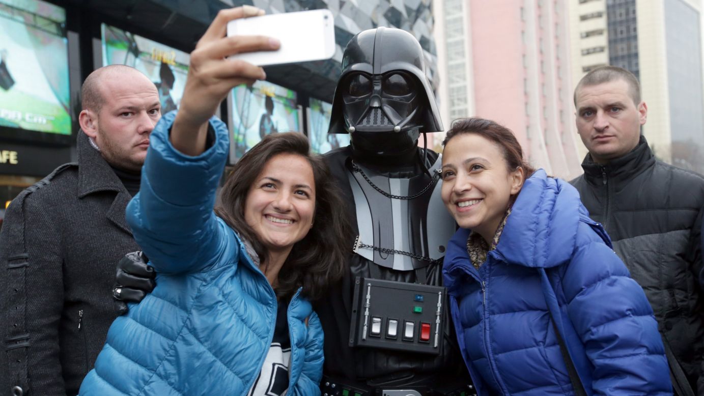 A person dressed as "Star Wars" character Darth Vader poses with two women during an election campaign event in Kiev, Ukraine, on Wednesday, October 22.