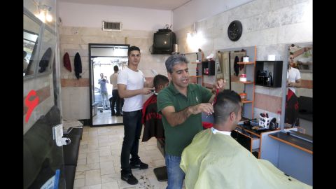 Men get their hair cut in a barbershop in south Tehran.