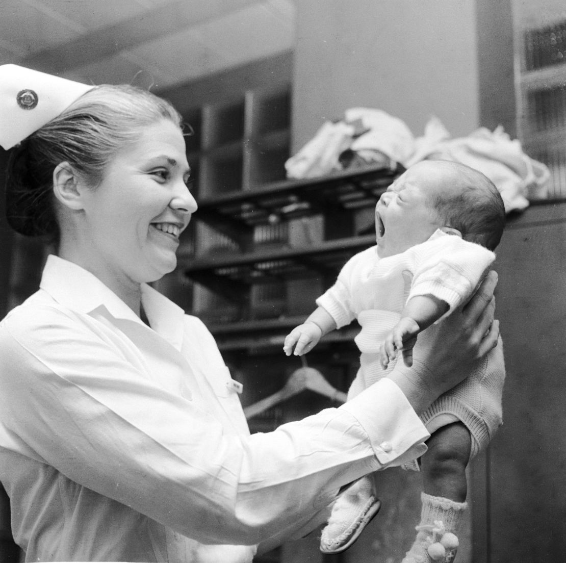 circa 1955: A nurse lifting up a three month old baby boy at Mount Sinai Hospital in New York. (Photo by George Heyer/Three Lions/Getty Images)