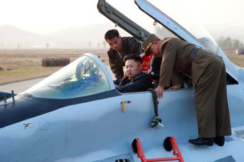 Kim sits in the pilot's seat of a fighter jet during the inspection.