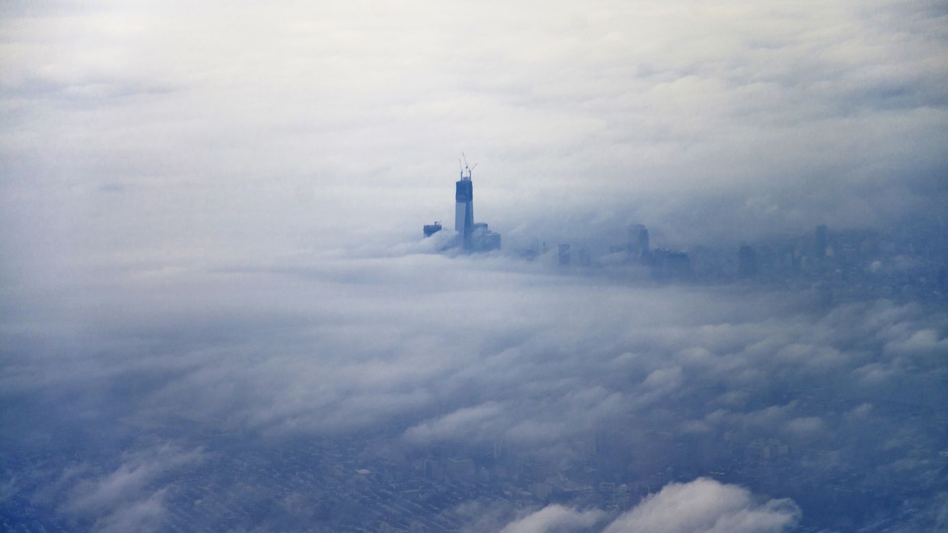 The newly constructed One World Trade Center building, dubbed "Freedom Tower," rises above the clouds on December 2, 2012, in an aerial photo taken from an airplane leaving New York's LaGuardia Airport.    