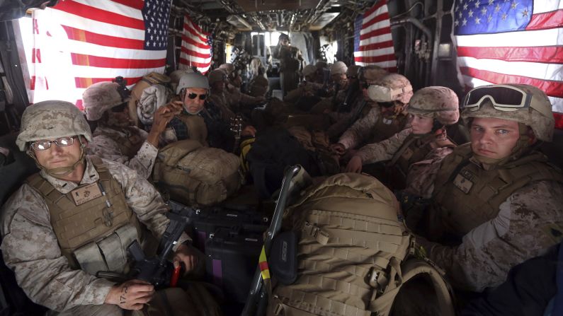 U.S. Marines sit on board a helicopter at an air base in Afghanistan on Monday, October 27. A fleet of planes and helicopters airlifted the last U.S. and British forces from a key base in southern Afghanistan, one day after the international coalition closed the massive facility and handed it over to the Afghan military.