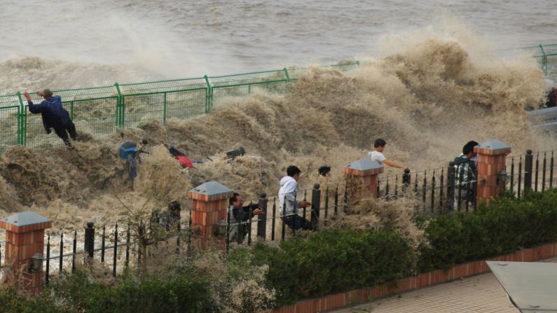 A tidal bore wave hits tourists in Hangzhou, China, on Monday, October 27.