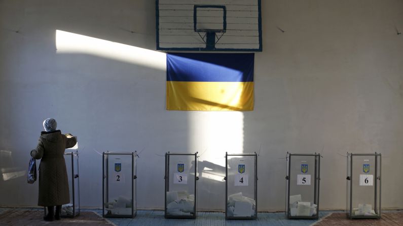 At a school gym in Semyonovka, Ukraine, a woman casts a ballot in the country's parliamentary election on Sunday, October 26. 