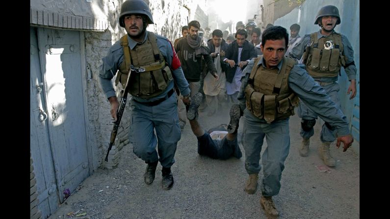 Afghan security forces drag a gunman's body after he was killed in a clash with police Tuesday, October 28, in Herat, Afghanistan. A police chief said gunmen had attacked a checkpoint in Herat one day earlier, killing two police officers.
