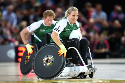 In September 2014, Phillips and her husband took part in a wheelchair rugby exhibition match during the Invictus Games for war veterans organized by her cousin Prince Harry (pictured behind). 