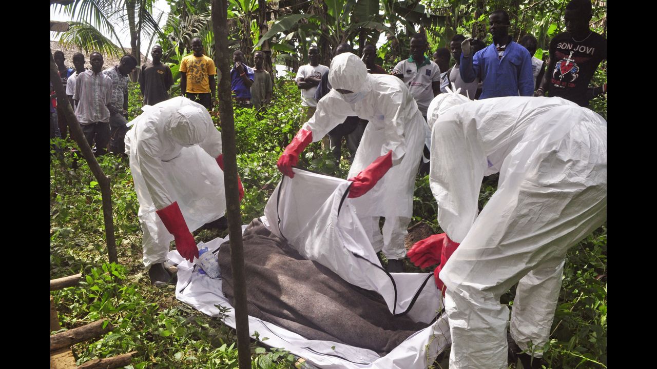 Health workers in Monrovia cover the body of a man suspected of dying from the Ebola virus on October 31, 2014.