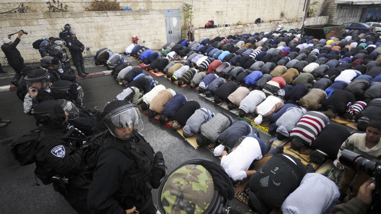 Israeli border police block a road in Jerusalem as Muslims pray Friday, October 31. A day after taking the rare step of closing the Temple Mount, Israel partially reopened access for Muslim prayers Friday. But midday access was granted only to men over 50 and women. Israeli police said this was meant to prevent demonstrations by young Muslim men following the recent shootings of a controversial rabbi and a Palestinian suspect in the rabbi's shooting.