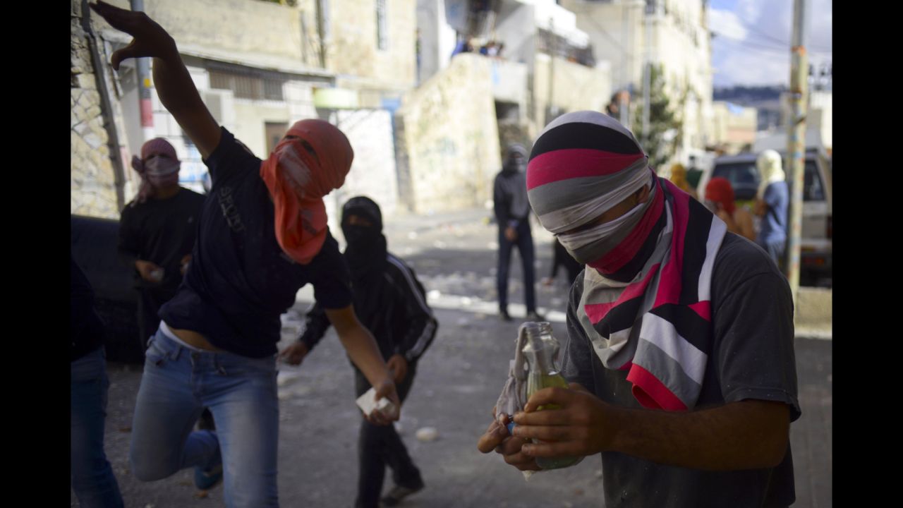 Palestinians throw stones in the streets of Jerusalem on October 30.