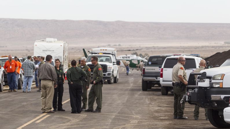 Law enforcement officers gather near the site where SpaceShipTwo exploded and crashed.