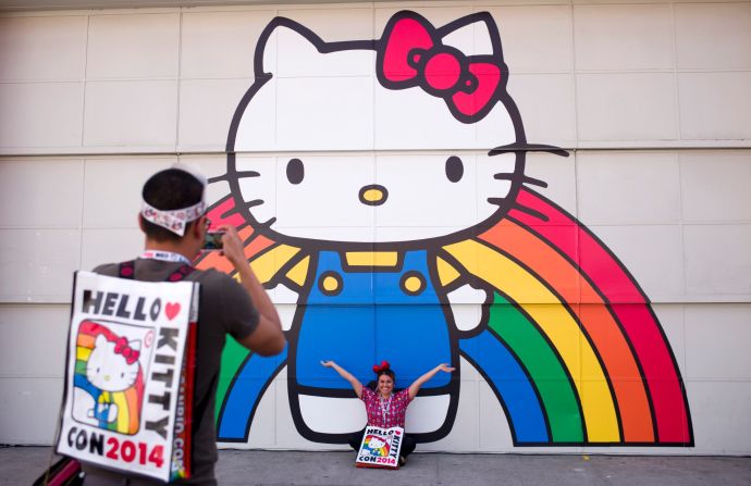 Keith Nunez, left, takes pictures of his wife, Carolina, in front of a Hello Kitty mural on Thursday, October 30. The first Hello Kitty fan convention was held to honor the character's 40th birthday. The event takes place in Los Angeles and runs from October 30 to November 2.