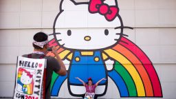 Keith Nunez, left, takes pictures of his wife, Carolina, at the first-ever Hello Kitty fan convention,  Hello Kitty Con, held at the Geffen Contemporary at MOCA, Thursday, Oct. 30, 2014, in Los Angeles. The convention was held to honor the character's 40th birthday. (AP Photo/Jae C. Hong)