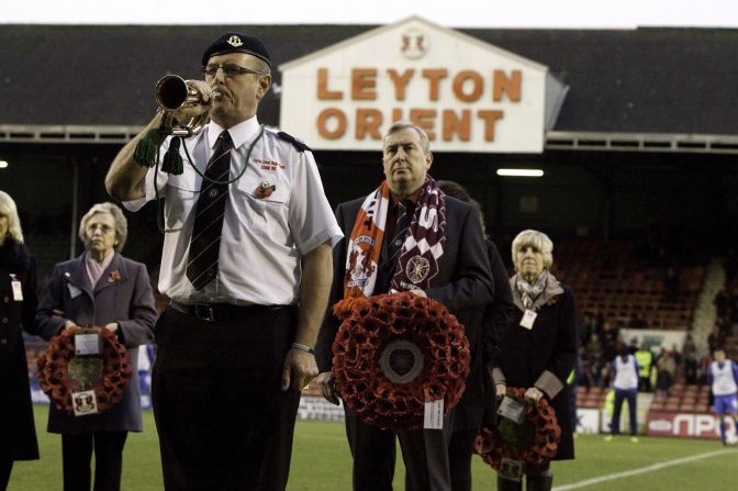 A man wears a Hearts scarf and holds a wreath to represent the Scottish club during a remembrance ceremony at Orient's stadium in east London.