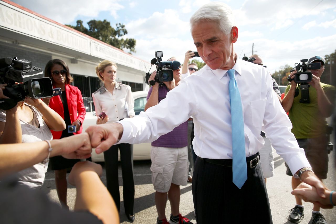 Crist bumps fists with a supporter as he makes an Election Day visit to thank volunteers at the Total Image Hair Salon in Tampa, Florida. 