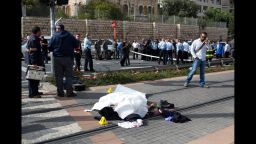 The body of Palestinian attacker lies covered on the rails of Jerusalem's tramway on November 5, 2014 after he was killed when he deliberately rammed his vehicle into a crowd of pedestrians in Jerusalem. One person was killed and at least nine others wounded. Police described the incident as a "hit and run terror attack" and said it took place in the same area as a similar attack two weeks ago, in which a Palestinian rammed a car into a crowd killing a woman and a baby.  AFP PHOTO/MENAHEM KAHANA        (Photo credit should read MENAHEM KAHANA/AFP/Getty Images)