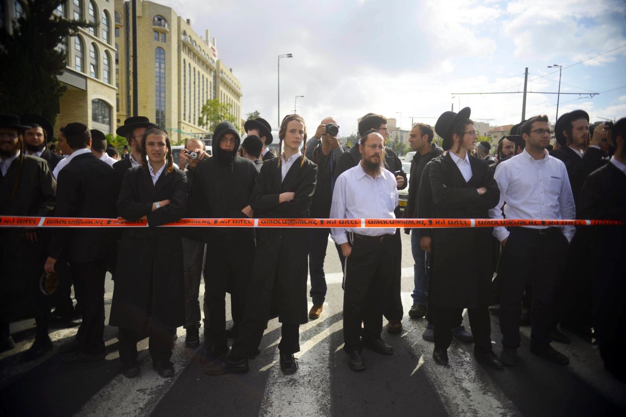 Onlookers gather at the crime scene. A police spokeswoman said the attacker was 38 years old and had been released from prison recently.