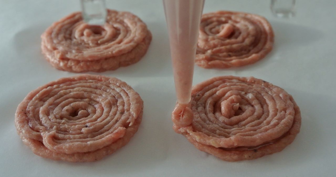 Ingredients are loaded into stainless steel capsules. Load them with beef to print out mini burgers.