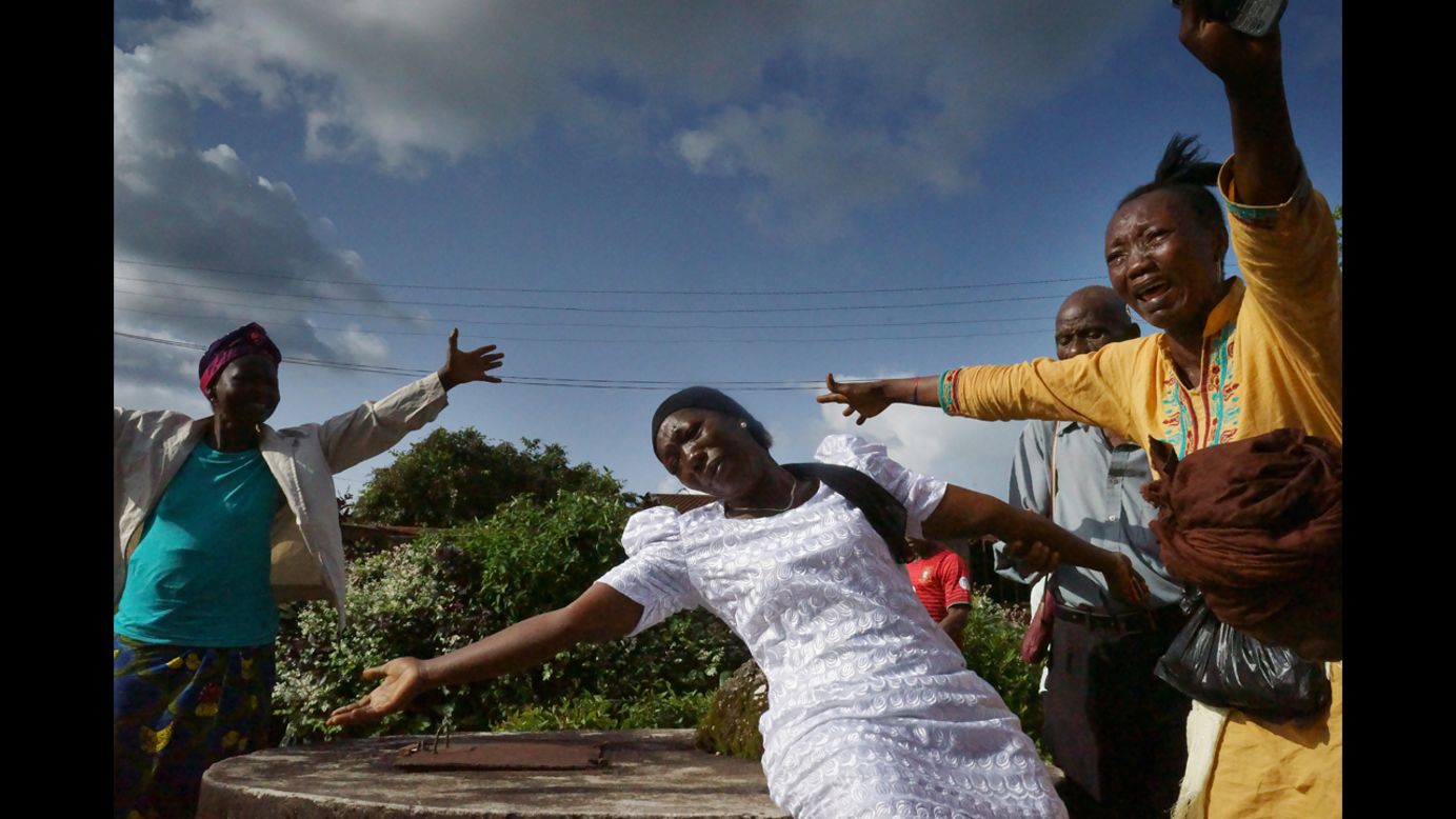 The wife of a man who died from ebola mourns during his funeral. (Luigi Baldelli/ECHO)