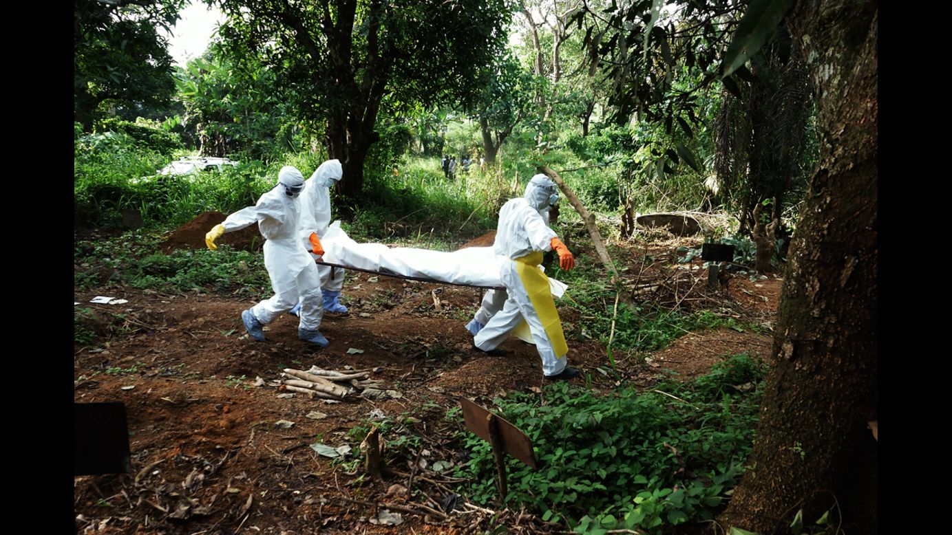 Health workers carry the body of a person who died from ebola to the cemetery. (Luigi Baldelli/ECHO)