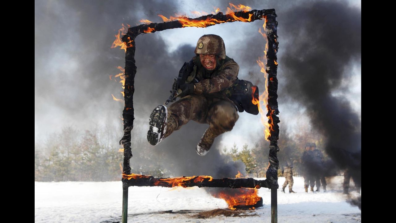 A People's Liberation Army soldier jumps through a burning obstacle during a training session in Heihe, China, near the border with Russia on Friday, October 31.