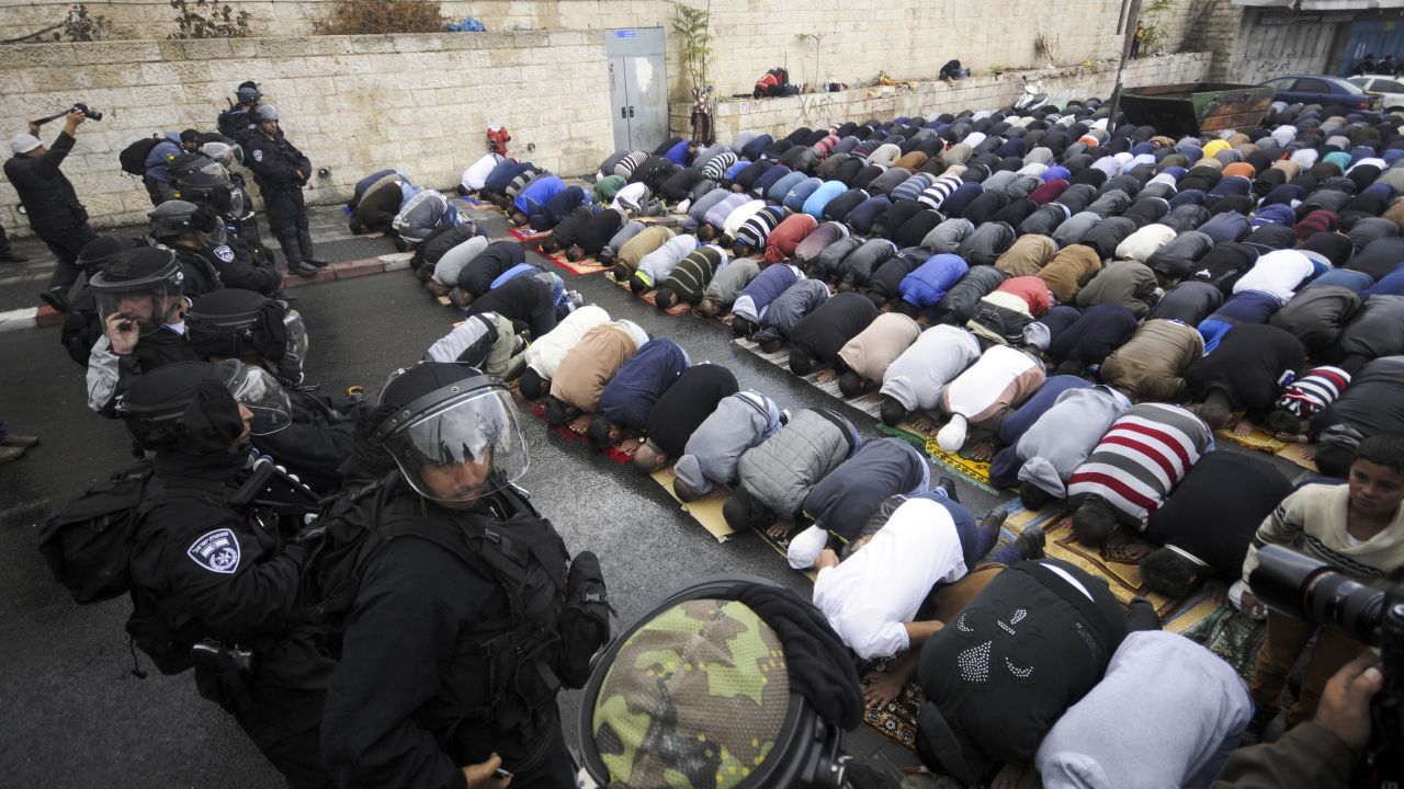 Israeli border police block a road in Jerusalem as Muslims pray Friday, October 31. A day after taking the rare step of closing the Temple Mount, Israel partially reopened access for Muslim prayers Friday. But midday access was granted only to men 50 or older and to women. Israeli police said this was meant to prevent demonstrations by young Muslim men following the recent shootings of a controversial rabbi and a Palestinian suspect in the rabbi's shooting.