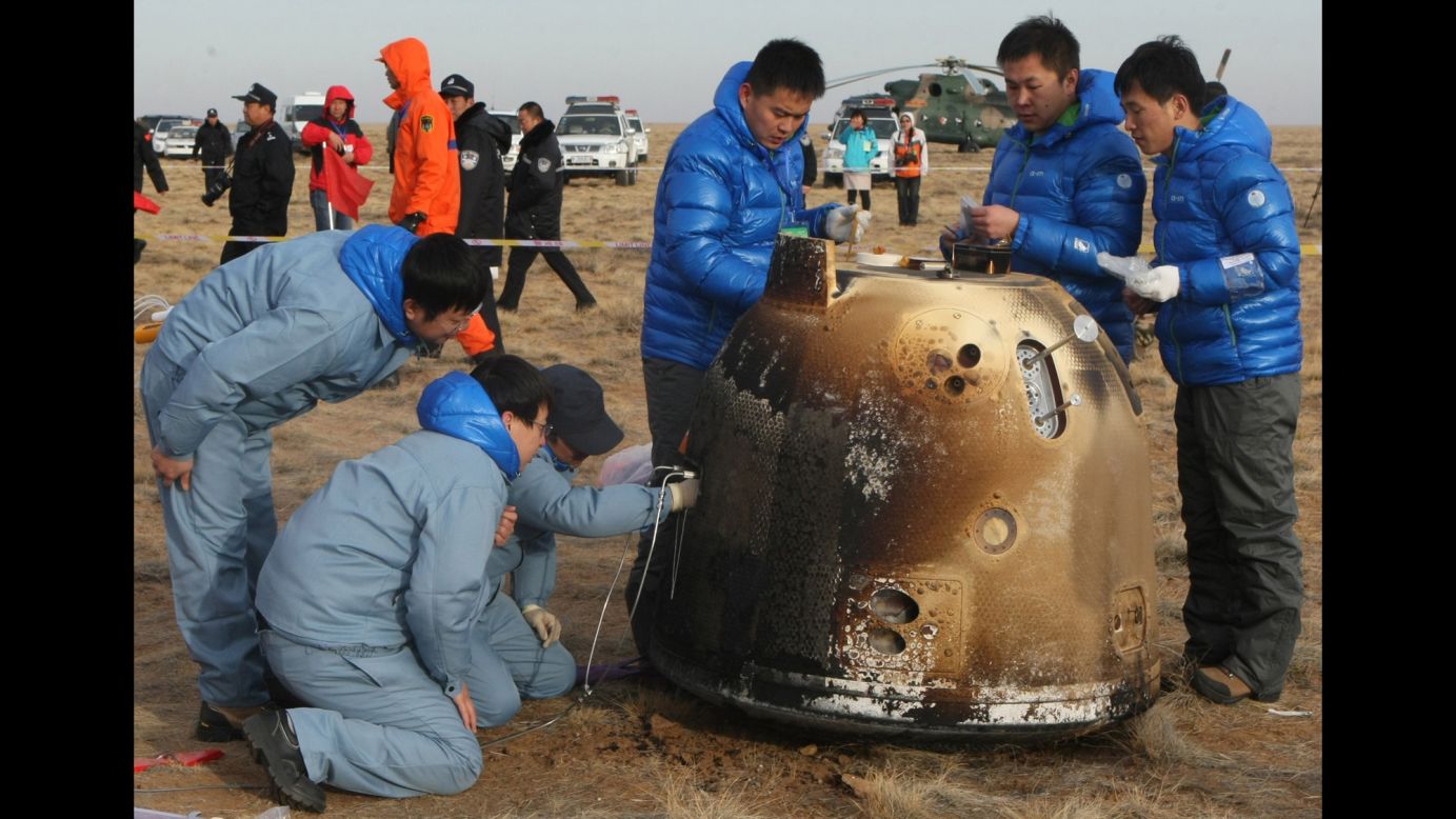 Technicians check an unmanned probe on Saturday, November 1, after it returned from its mission to the moon and landed in north China's Inner Mongolia region. The landing completes China's first return mission to the moon.