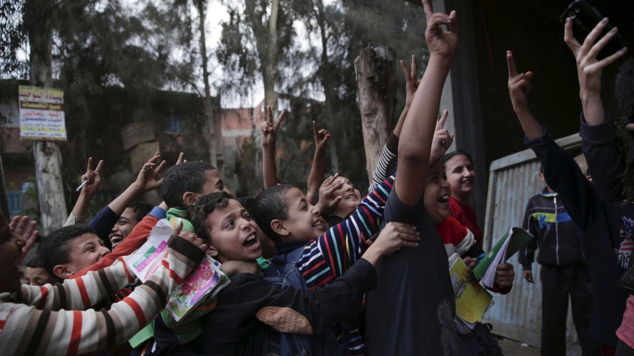 Egyptian children push each other as a woman takes a photograph of them with her phone on Wednesday, November 5, in the village of Dierb, Egypt, about 75 miles northeast of Cairo.