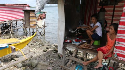 Kristian Kano, 25, cooks her daily meal with her mother in their home in one of Tacloban's coastal "danger zones."